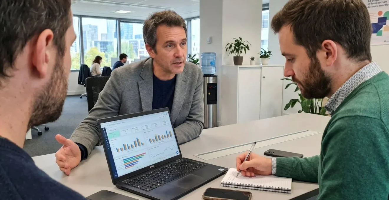Deux personnes assises à un bureau analysent ensemble des graphiques de performance d'appels affichés sur un écran d'ordinateur portable lors d'une session de coaching